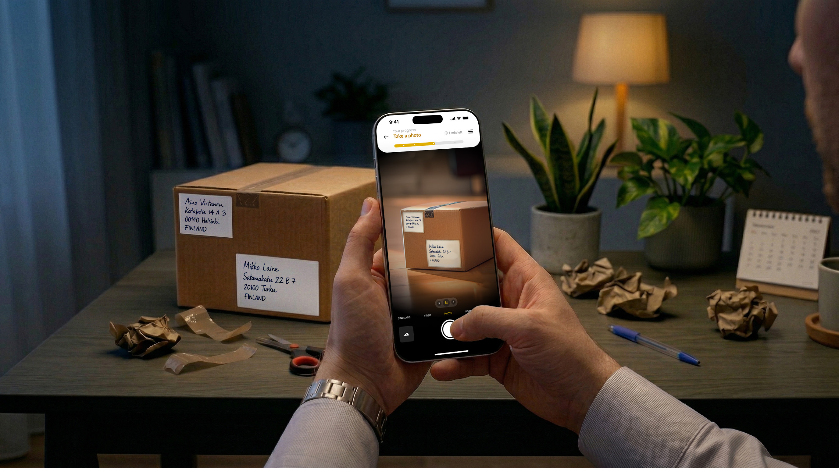 A person taking a photo of a labelled parcel.