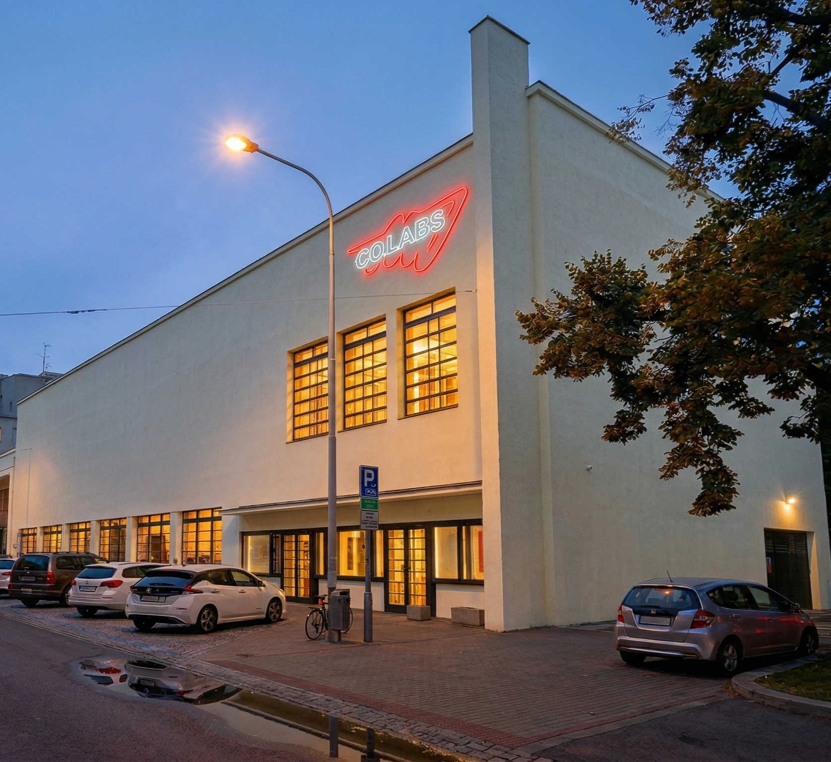 A CO.LABS theatre with the logo concept on its facade as a neon sign